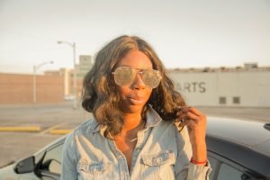 Tasha Robinson Imperfect Concepts wearing: Sunglasses: Quay X Desi, Shirt: Target, Jeans: American Eagle, Shoes: Charlotte Olympia and Bag: Balenciaga