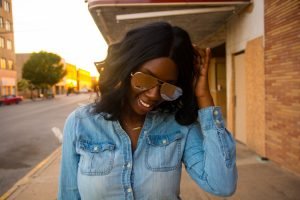 Tasha Robinson Imperfect Concepts wearing: Sunglasses: Quay X Desi, Shirt: Target, Jeans: American Eagle, Shoes: Charlotte Olympia and Bag: Balenciaga