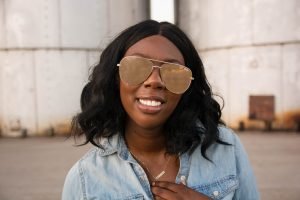 Tasha Robinson Imperfect Concepts wearing: Sunglasses: Quay X Desi, Shirt: Target, Jeans: American Eagle, Shoes: Charlotte Olympia and Bag: Balenciaga