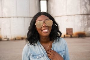 Tasha Robinson Imperfect Concepts wearing: Sunglasses: Quay X Desi, Shirt: Target, Jeans: American Eagle, Shoes: Charlotte Olympia and Bag: Balenciaga