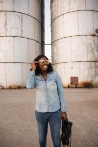 Tasha Robinson Imperfect Concepts wearing: Sunglasses: Quay X Desi, Shirt: Target, Jeans: American Eagle, Shoes: Charlotte Olympia and Bag: Balenciaga